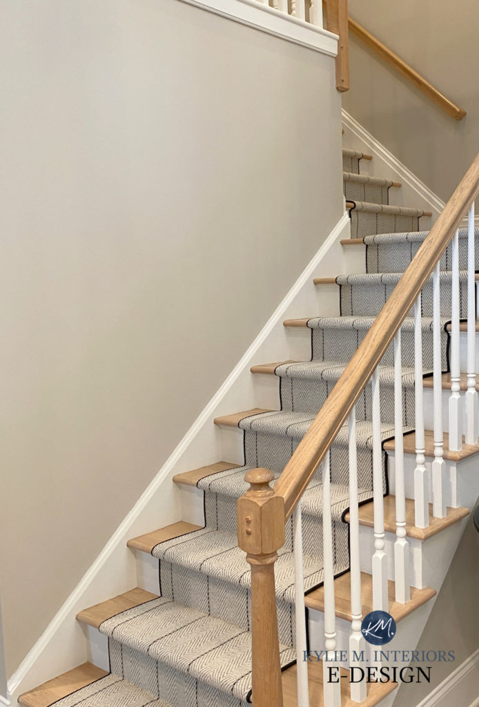 Benjamin Moore Cloud White trim and Edgecomb Gray paint color on walls with striped carpet stair runner and natural wood hand railing. Kylie M Interiors
