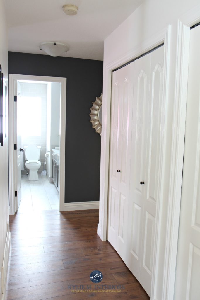 Hallway update with laminate wood look flooring, Benjamin Moore Gray feature wall, Sherwin Williams Creamy and door to bathroom. Kylie M INteriors E-design