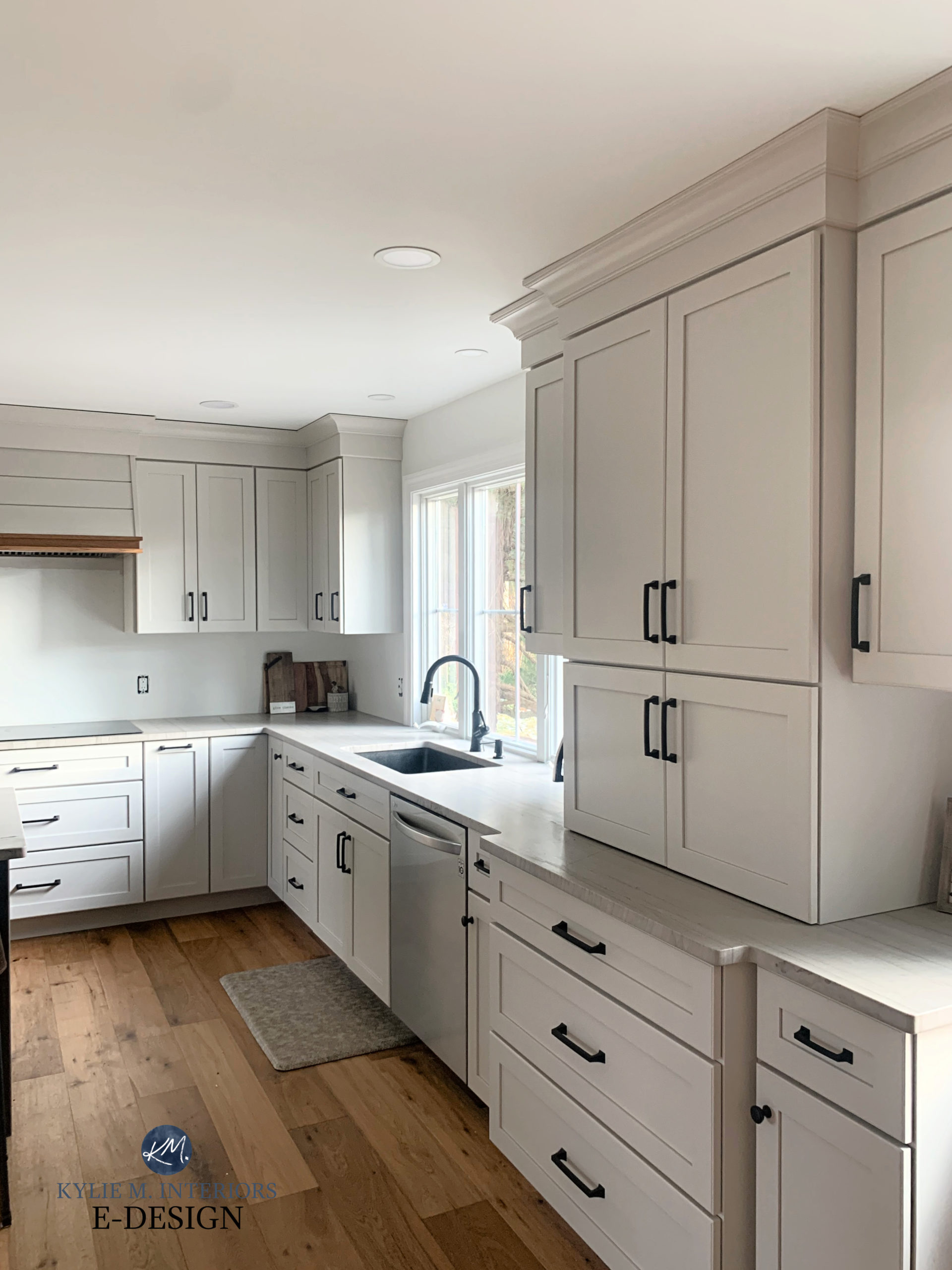 Sherwin Williams Agreeable Gray greige taupe off white painted cabinets, White Macaubus quartzite countertops, wood floor. Black hardware. Kylie M Interiors Edesign