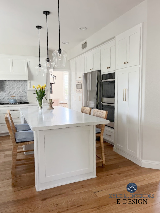 Sherwin Williams PUre White painted cabinets, Vadar White Aura quartz countertop, stainless steel appliances, wood floor, subway tile, Classic Gray walls. Kylie M Interiors