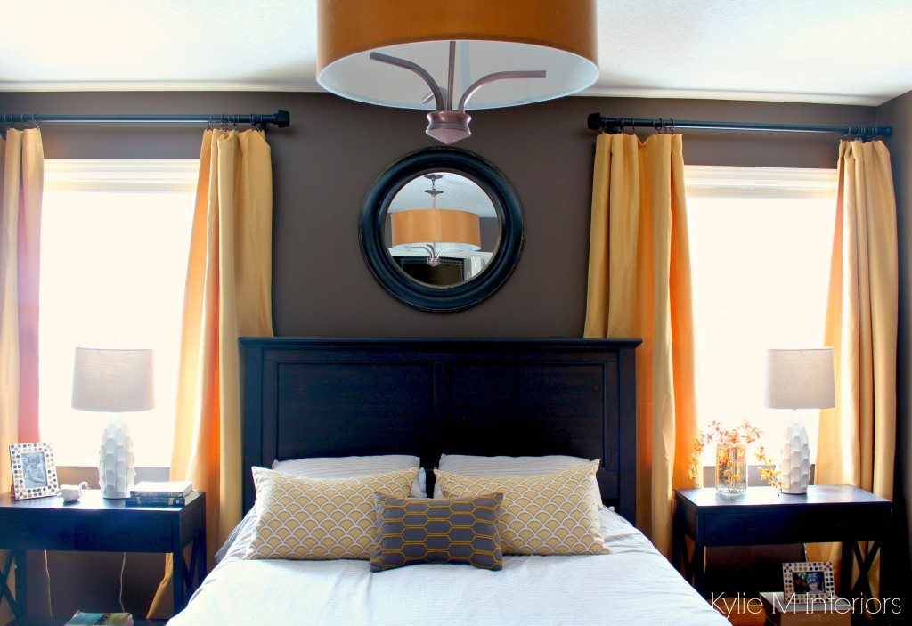 Dark bedroom with gold and yellow accents with dark wood furniture. Benjamin Moore Brown Horse